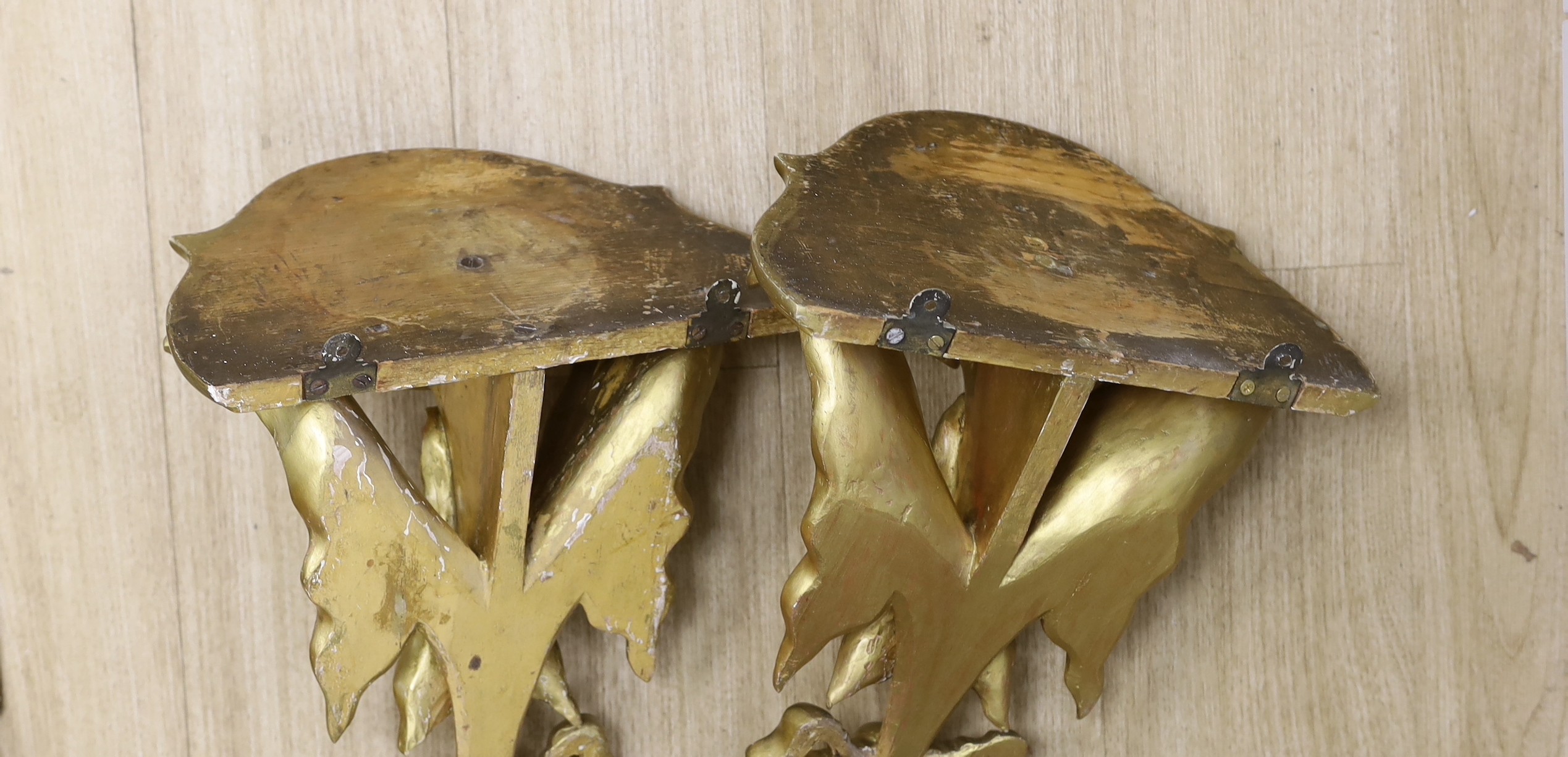A pair of decorative ivy carved giltwood wall brackets, 40cms high